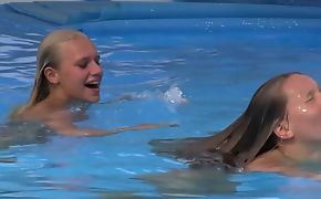 Two beautiful girls swimming and licking by slay rub elbows with pool