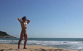 Na praia nudista tomando sol